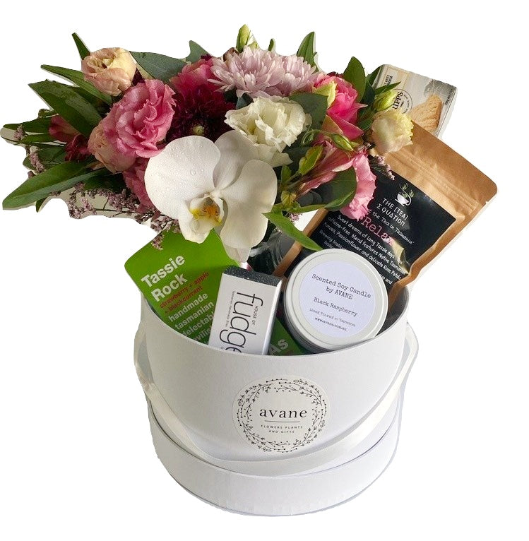 A fabulously luxe hamper with everything lovely. All Tasmanian goodies including:   - A gorgeous posy of seasonal pink and white blooms in a glass vase   - Black Raspberry Soy Candle   - Tasmanian Devil Fudge (100g)  - "Relax" Tasmanian Tea  - Cripps Shortbread  - Tassie Rocks Candy   This gorgeous gift is packaged in a lovely hamper box, wrapped and ribboned and hand delivered with a custom card message. How wonderful it is to know that in this hectic world, your recipient will be able to relax and indulge